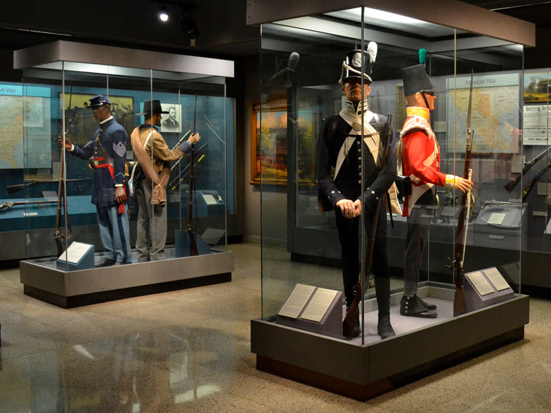 Mannequins of Soldiers on display in glass enclosures in the middle of a room inside the West Point Museum.